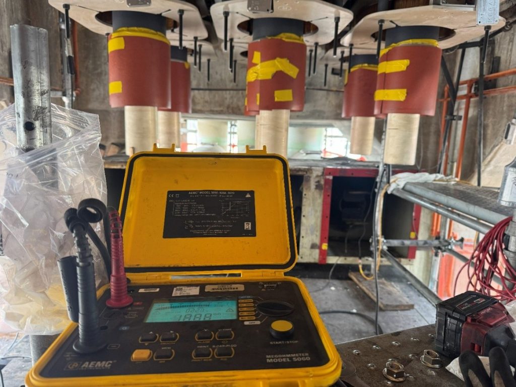 5,000-volt Megger tester connected to the copper stator windings of a 13,800 V, 135 MVA generator during a polarization index test.